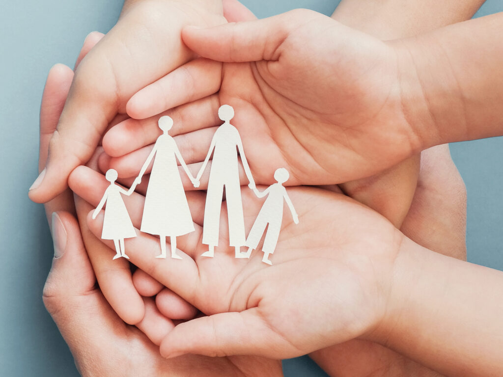 Adult and children hands holding paper family cutout, family home, foster care, homeless charity support concept, family mental health, international day of families